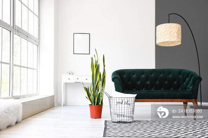 带绿色沙发、室内植物和台灯的浅色客厅内部