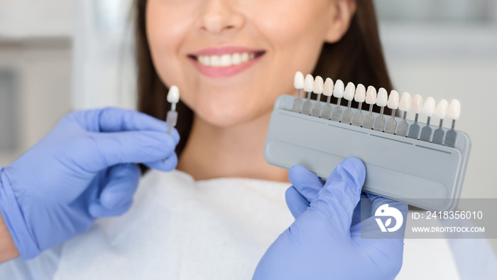 Doctor applying sample from tooth scale to smiling patient teeth