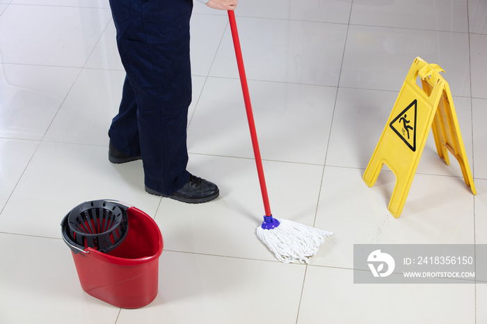 Cleaning Floor With Caution Wet Floor Sign In Office with mob