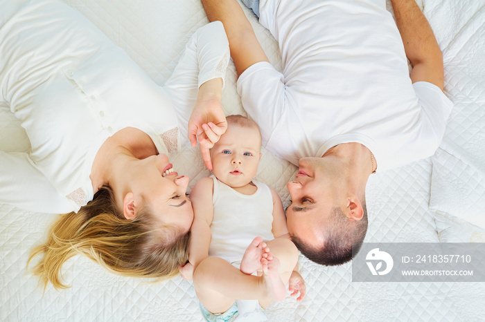 The concept of a happy family. Top view of a mom, dad and baby b