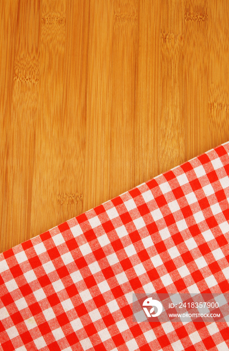Red tablecloth on wooden table background