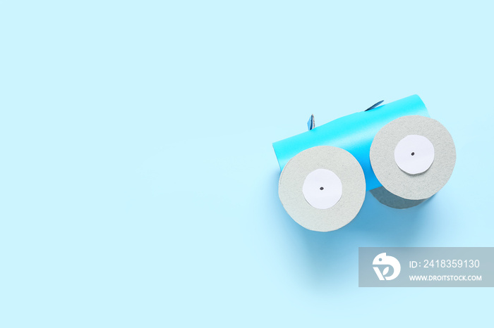 Figure of car made of cardboard tube for toilet paper on color background