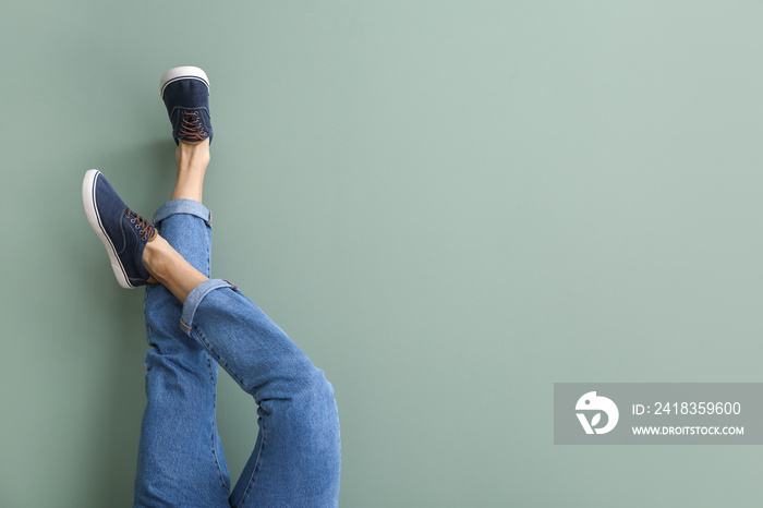 Young man in stylish shoes on color background