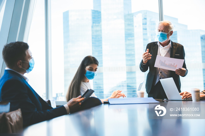 A group of businessmen meeting a work plan in modern office By wearing a surgical mask to prevent th