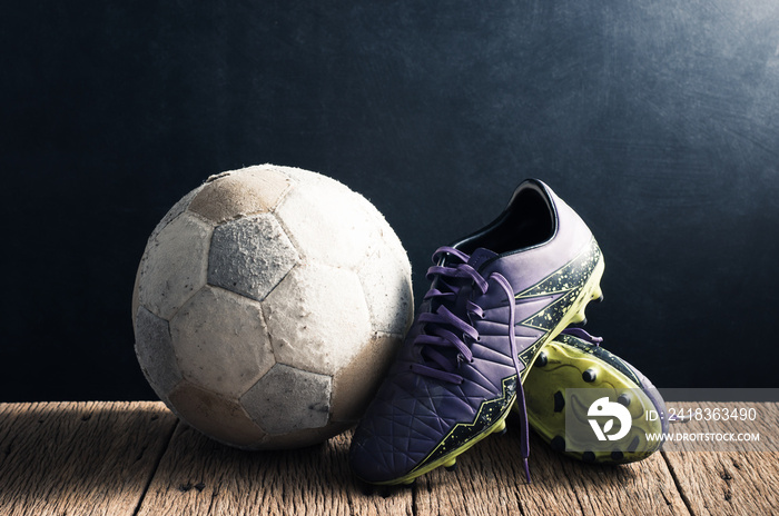 still life photography : old football and football shoes on old wood floor against art dark backgrou