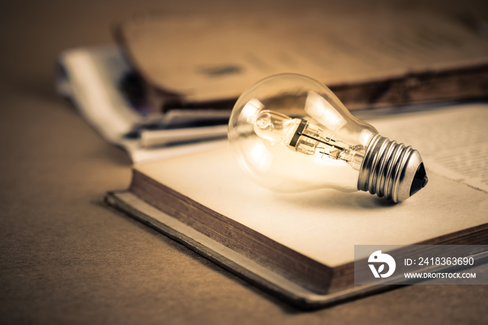 Glowing Bulb and Old Books