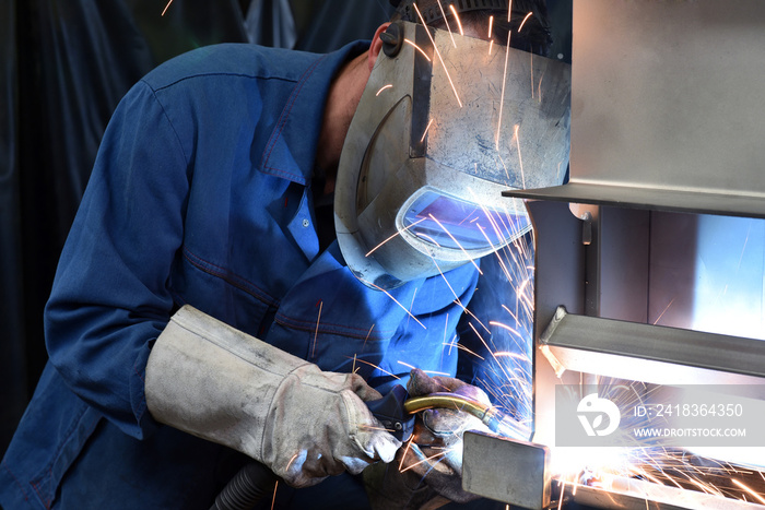 welder works in metal construction - construction and processing of steel components