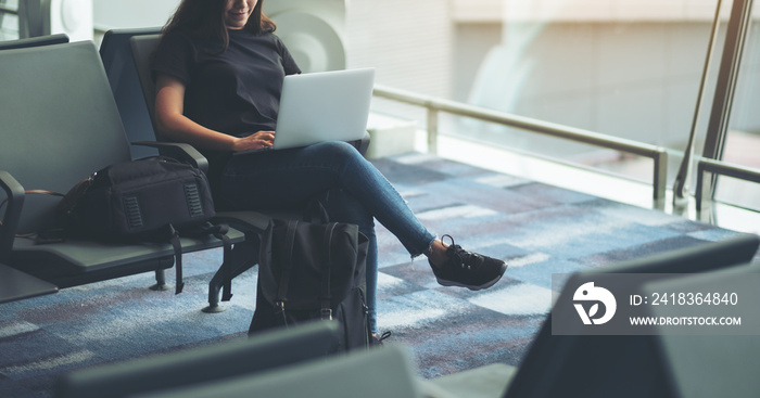 A woman traveler using laptop computer while sitting in the airport