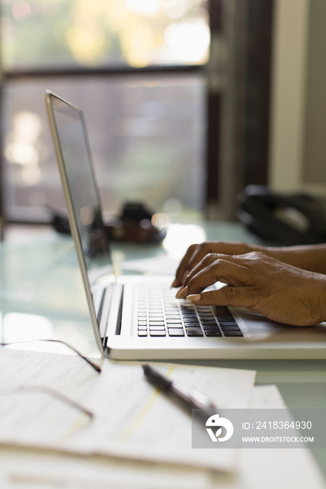 Hands of businesswoman typing on laptop