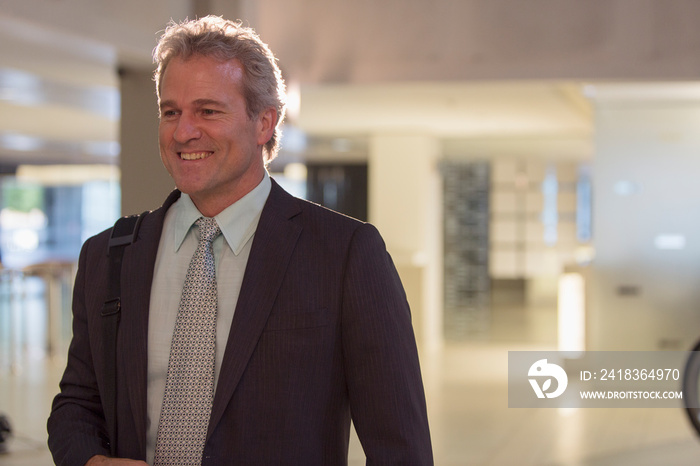 Smiling senior businessman in office lobby