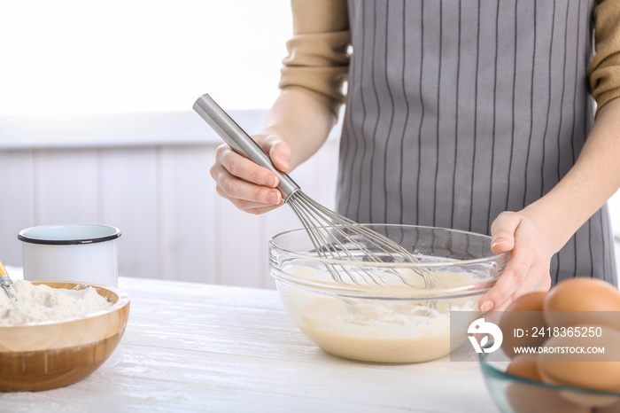 Woman making dough on kitchen table