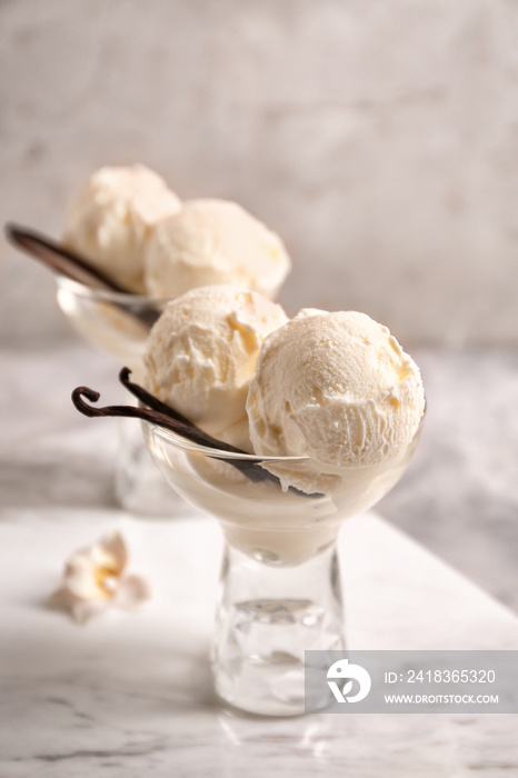 Glasses with delicious vanilla ice cream on table