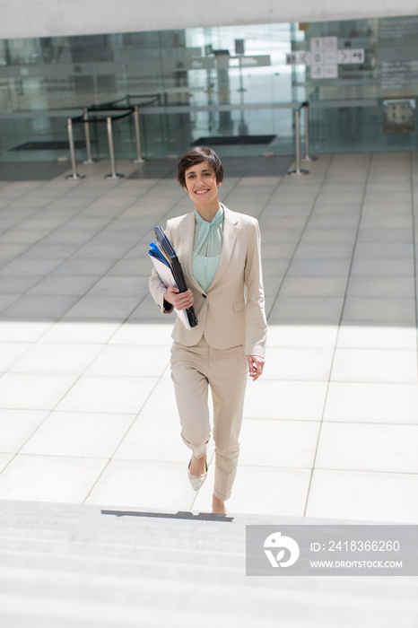 Portrait confident young businesswoman climbing steps