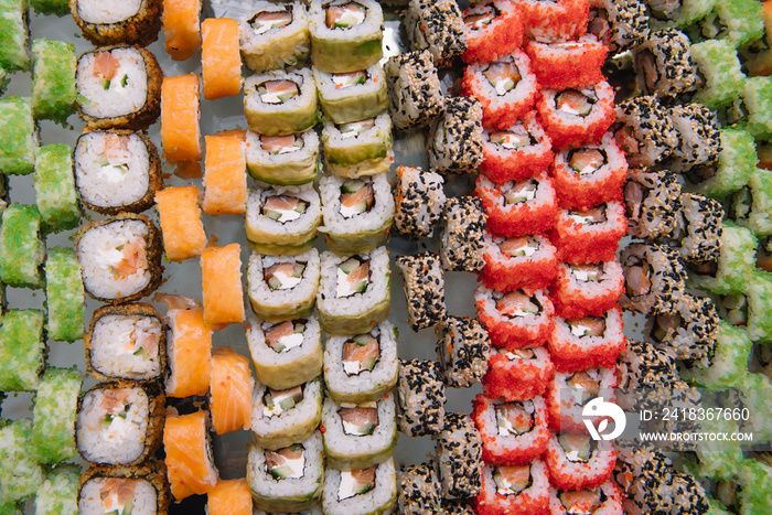 Decorated catering banquet table with different sushi rolls and nigiri sushi plate assortment on a p