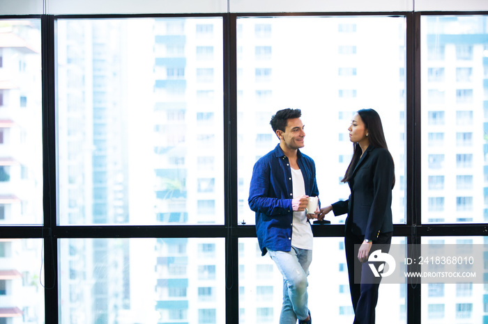 Two young creativity discussing about work is a window office