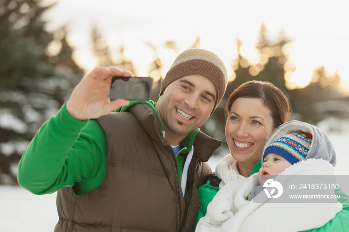 Family taking self-portrait with smart phone in winter