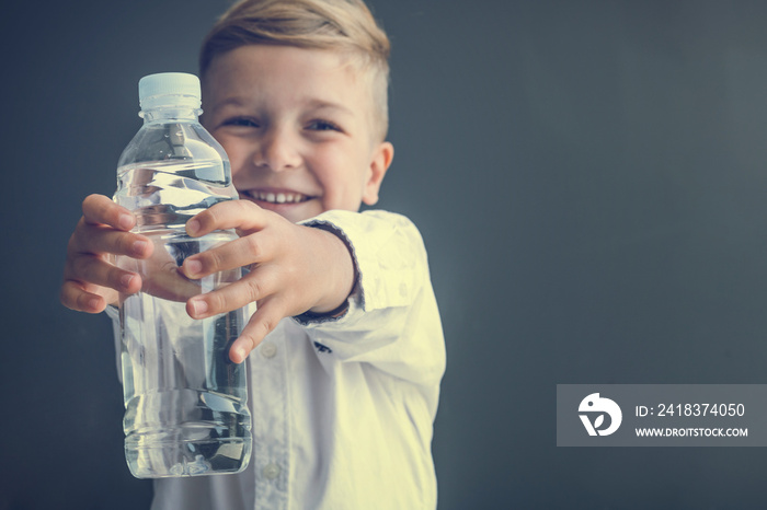 Happy boy holding bottle of water.