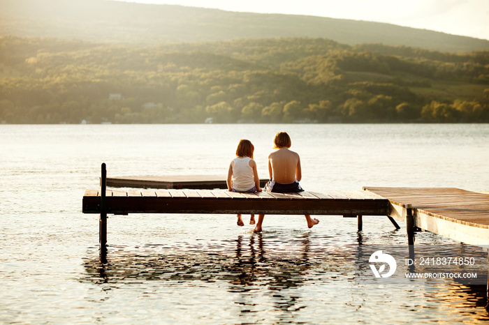 Rear view of friends sitting on jetty