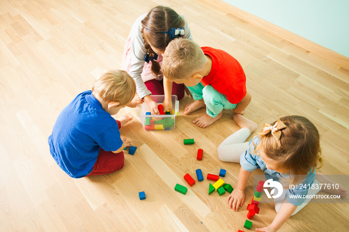 Children at day care centre putting toys into box