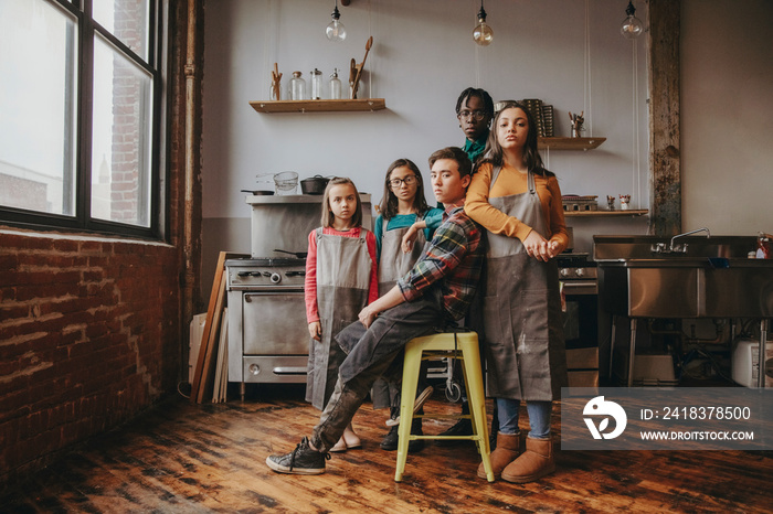 Portrait of serious confident friends wearing aprons in cooking class