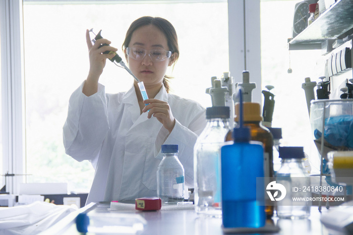 Female scientist holding pipette and test tube