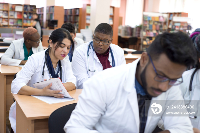 一所医科大学的跨国年轻学生在坐着学习医学期刊