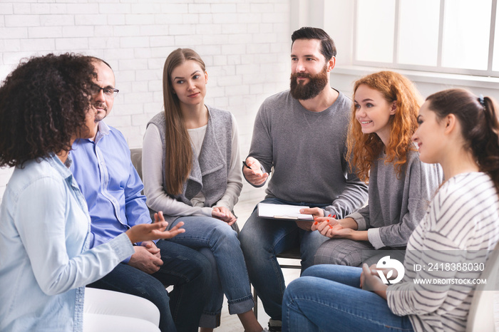 Man psychiatrist talking with patients at rehab group meeting