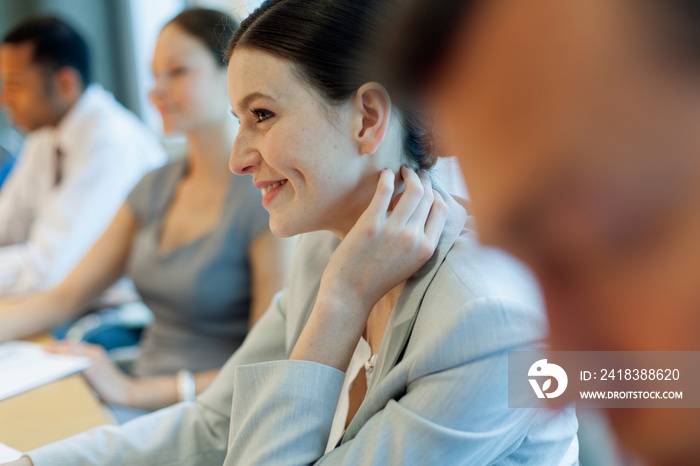 Smiling corporate businesswoman listening in music