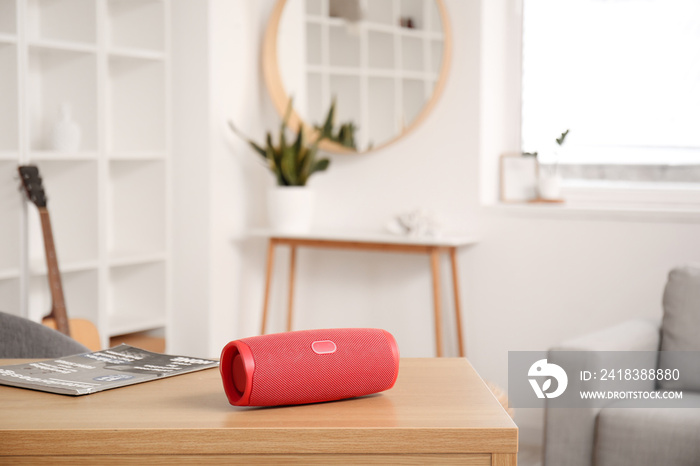 Wireless portable speaker on wooden table in light room