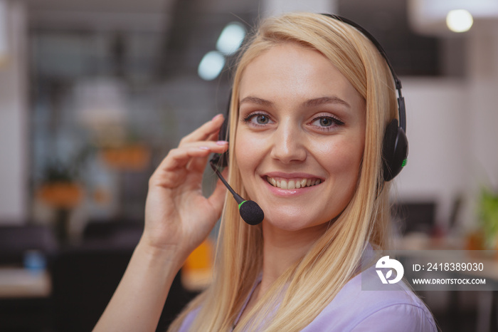 Close up shot of a cheerful beautiful young woman wearing headset with microphone, working at custom