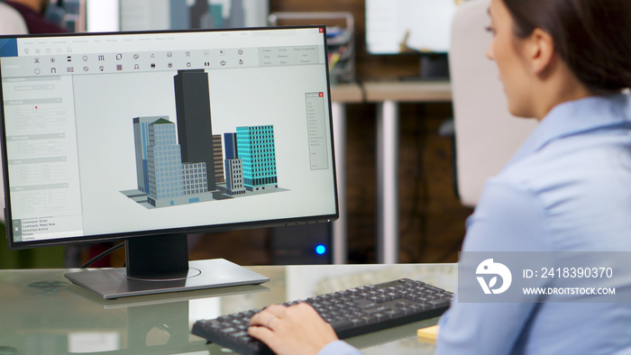 Young female architect working on computer with 3d building models