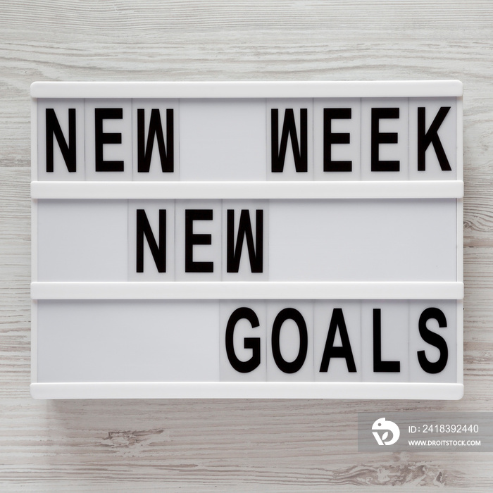 Modern board with text New week new goals over white wooden background, top view. From above, flat