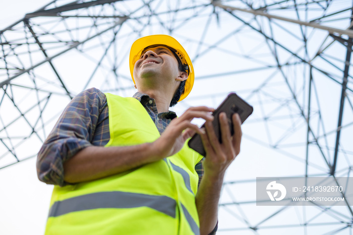 Electrical engineers asian using smartphone inspect the high voltage pole