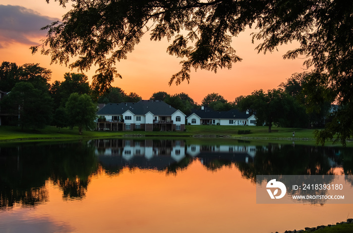 Beautiful view of sunset over Midwestern  suburban neighborhood  by a lake