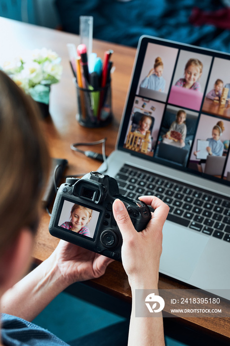 Female photographer working on photos on laptop and camera. Woman editing retouching browsing photos