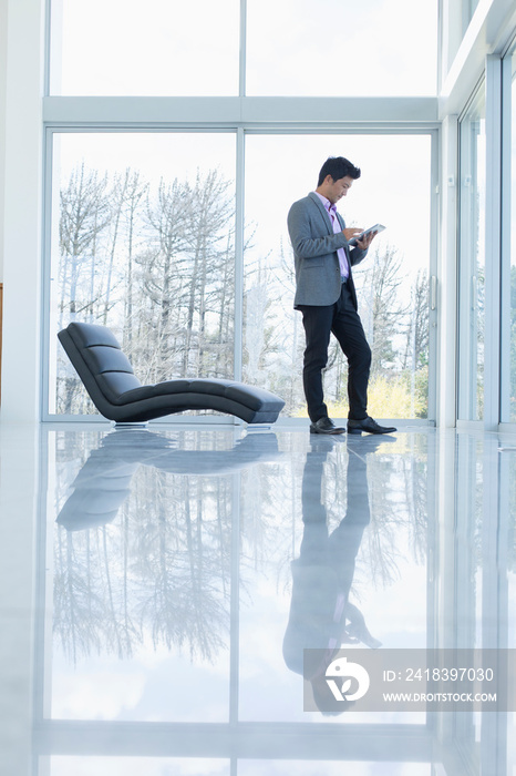 Businessman using digital tablet in modern house