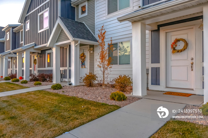 White front door of colorful townhomes with wreath