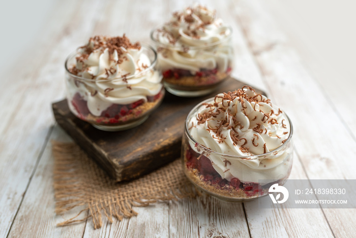 White Chocolate mousse dessert in a glass with raspberry and chocolate shavings