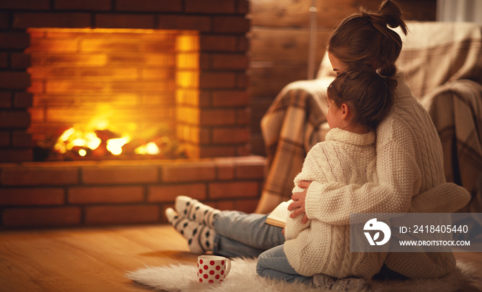 冬日的夜晚，家庭母亲和孩子在壁炉旁拥抱温暖。