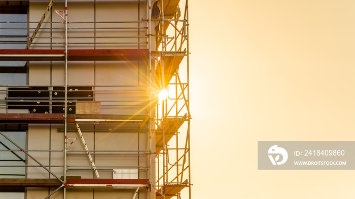 Baugerüst auf einer Baustelle Gewerbebau mit Sonnenstrahlen im Gegenlicht