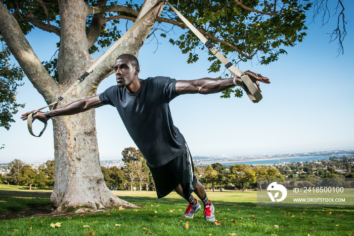 Young man training with lunge rope in field