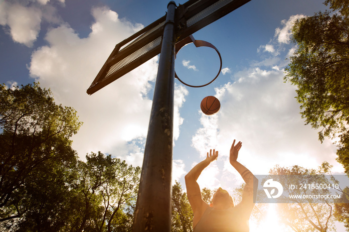 Men playing basketball at sunny day