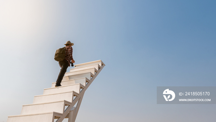 A white staircase with a young man holding a camera walks up to look at the beautiful sky.