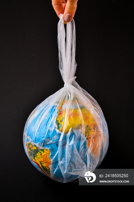 地球仪形式的球在一个塑料袋里。地球塑料污染的概念。World En
