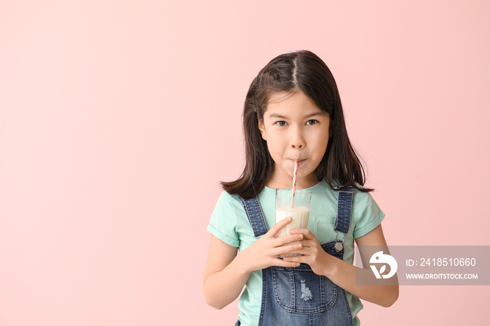 Cute Asian girl with milk on color background