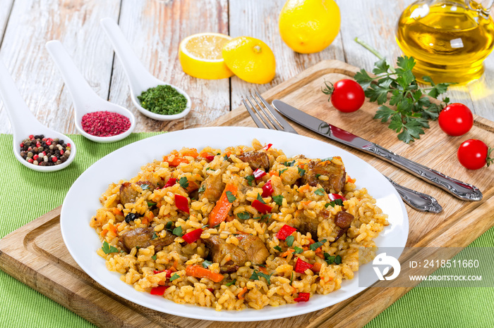 paella with meat, pepper, vegetables and spices on platter