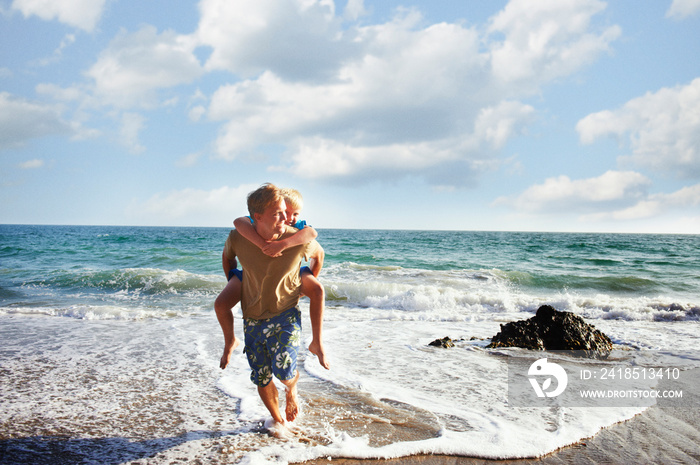 Father and son (8-9) playing on beach