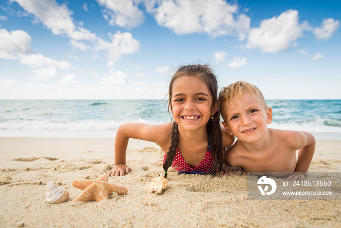 Children playing with a starfish on the beach