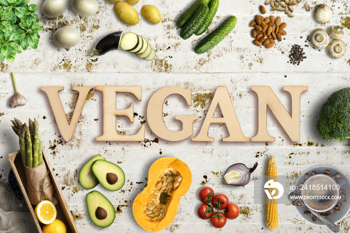 Word  vegan  in wooden letters with many cooking ingredients