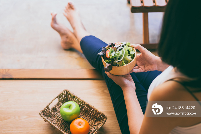 Woman hands holding and eating healthy salad for breakfast in the morning